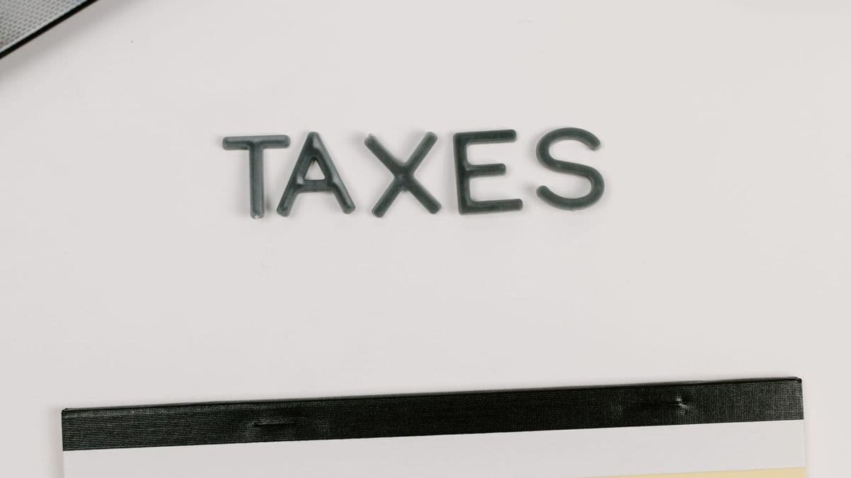 A desk with a calculator, notepad and TAXES lettering for end-of-financial-year planning